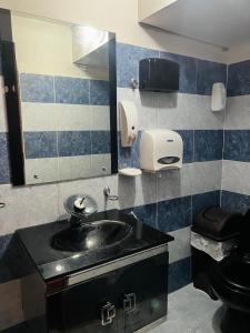 a bathroom with a black sink and a mirror at Four Season Hostel in Bogotá