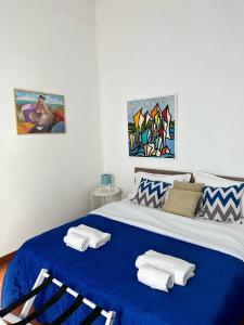 una camera da letto con un letto blu e asciugamani di Via Zara a Palermo