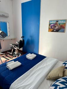 Un dormitorio con una cama azul y blanca con toallas. en Via Zara en Palermo