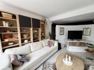 un soggiorno con un divano bianco e un tavolo di Kazanlak LARGE GUEST HOUSE Apartment near Center with Full Kitchen & Dining Room, King Beds, Garden Patio, Free Parking & Self Check-in Top Value! a Kazanlŭk