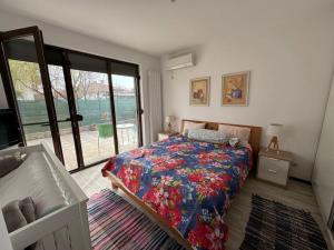 a bedroom with a bed with a floral bedspread at Large Guest House Apartment with Parking and Patio Garden, Near City Center & Kazanlak Stadium in Kazanlŭk