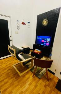 a living room with a chair and a television at 2 Bedroom Condo in the center of MM in Manila