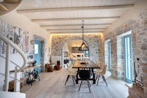 a dining room with a table and a stone wall at Elemani Villas in Areopoli