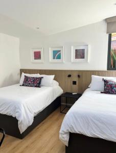 two beds sitting next to each other in a bedroom at Hermoso Departamento Frente al Aeropuerto in Mexico City