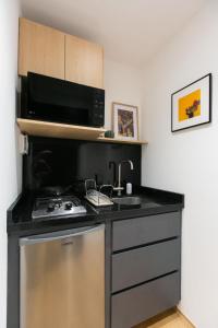 a kitchen with a stove and a microwave at Hermoso Departamento Frente al Aeropuerto in Mexico City