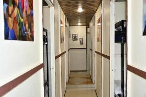 a hallway in a building with paintings on the walls at KSHIPRA GUEST HOUSE in Ujjain