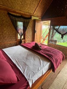 a large bed in a room with a window at Tetebatu Jungle Vibes in Tetebatu