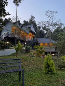 una casa con un banco delante de ella en Mountain Vibes Resort Wayanad, en Wayanad