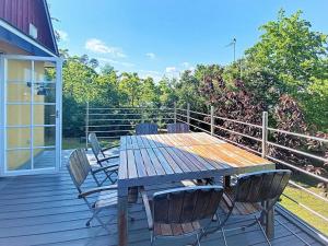 a wooden table and chairs on a deck at 4 person holiday home in KIVIK in Kivik
