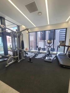 a gym with treadmills and machines in a room at Sky tower just next DOOR in Auckland
