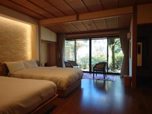 a hotel room with two beds and a large window at Kawakamiya Kasuitei in Gero