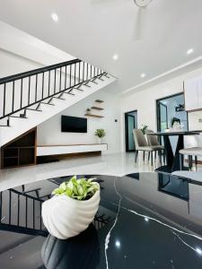 a living room with a staircase and a vase on the floor at TRaiOn House - Villa nguyên căn và Homestay in Mộc Châu