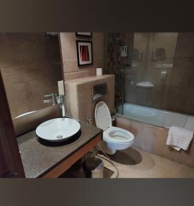łazienka z umywalką, toaletą i wanną w obiekcie HOTEL FLAMINGO w mieście Dżajpur