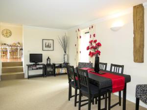 a dining room with a table and chairs and a television at 3 Hazlewood in Aldringham