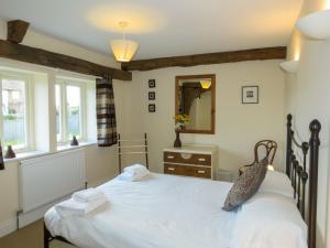 um quarto com uma grande cama branca e um espelho em 3 Hazlewood em Aldringham