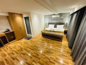 sypialnia z łóżkiem i drewnianą podłogą w obiekcie De Elaaf The Luxury Stay w mieście Śrinagar