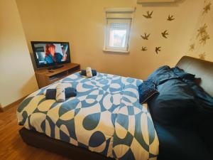 una camera con letto, divano e TV di Chambre climatisée et cosy Auberge du manala Hôtel 24 24 a Saint-Louis