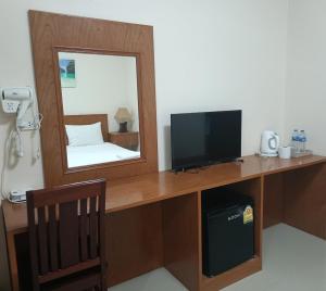 a room with a desk with a television and a mirror at Sj House Hotel Aonang in Ban Khlong Haeng