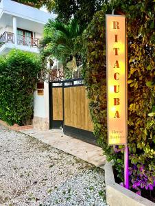 a sign in front of a building with a gate at Ritacuba House Boutique in Santa Marta