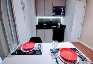 a kitchen with a table with red plates on it at Hotel M-RCURE Vila Olímpia - The Urban Duplex Studio - Red Velvet Deluxe Edition - By LuXXoR in Sao Paulo