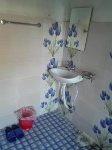 a bathroom with a sink and blue flowers on the wall at Best Hostel in Kathmandu