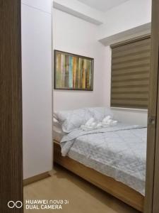 Un dormitorio con una cama en una habitación blanca. en 2BR Fully Furnished Unit at Fairview QC, en Manila