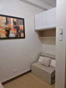 Una sala de estar con un sofá y un cuadro en la pared. en 2BR Fully Furnished Unit at Fairview QC, en Manila