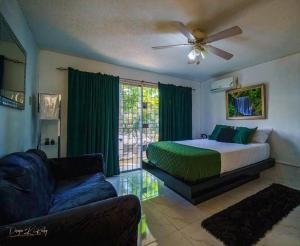 une chambre avec un lit, un canapé et un ventilateur dans l'établissement Fiwi-Own Chelsea Manor, Kingston, à Kingston