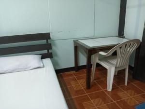 1 dormitorio con mesa y silla junto a la cama en Boondee House, en Mae Hong Son