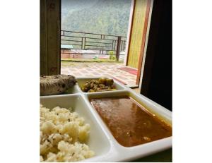 Natraj Heli Resort, Sersi في Phata: صينية طعام مع الرز ونافذة