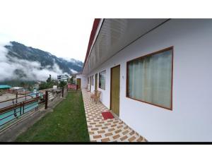 un edificio con una gran ventana en su lateral en Natraj Heli Resort, Sersi en Phata