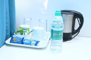 a bottle of water sitting next to a container of toiletries at Hotel Terminal View in Bangalore