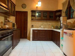 a large kitchen with wooden cabinets and a refrigerator at Dili's Homestay - Private Villa in Kandy