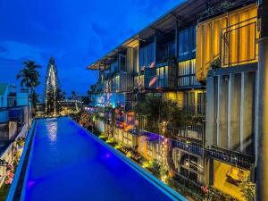 a swimming pool in front of a building at night at Amacon Hotel & Coffee in Buôn Kô Sir