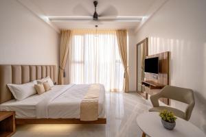 een hotelkamer met een bed en een televisie bij Hotel Darshan Executive in Tuljapur