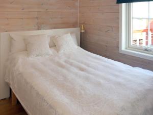 un letto bianco in una stanza con una finestra di 7 person holiday home in KLOKKARVIK a Klokkarvik
