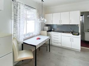 cocina con armarios blancos, mesa y ventana en Holiday home Søvik, en Syvik