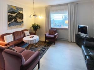sala de estar con sofá, mesa y TV en Holiday home Søvik, en Syvik