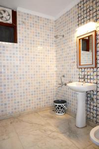 uma casa de banho com um lavatório e um espelho em Ganeshwaram Hotel Sector-45 Noida em Noida
