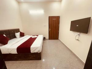 a hotel room with a bed and a television at The Lord Krishna Residency Vrindavan in Vrindāvan