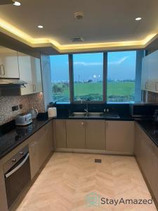 a kitchen with a sink and a large window at Amazing 2 BR in The Polo Residence Meydan in Dubai