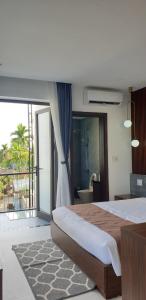 a bedroom with a large bed and a balcony at The Dragon Villa Hoi An in Hoi An
