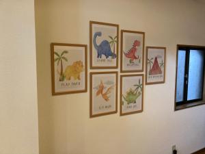 a wall with four pictures of dinosaurs on it at かつやま民泊きねん in Katsuyama