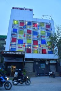 a building with people riding motorcycles in front of it at Hotel Nirvana Suites in New Delhi