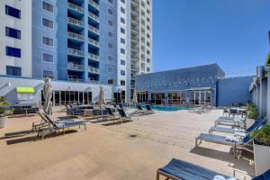 a patio with lounge chairs and a pool in a building at Diligence at The Platinum - NO Resort Fees and Free Parking in Las Vegas