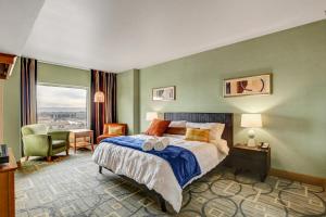 a bedroom with a bed and a chair and a window at Diligence at The Platinum - NO Resort Fees and Free Parking in Las Vegas