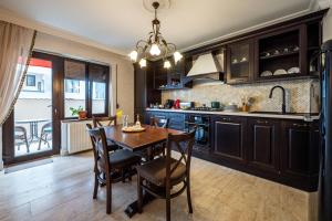 a kitchen with a wooden table and a dining room at Apartament Boem în Inima Oraşului Craiova in Craiova