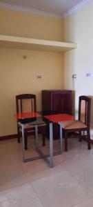 zwei Stühle, einen Tisch und zwei Tische und Stühle in der Unterkunft Sathya Service Apartment in Chennai