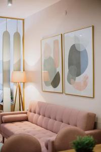 uma sala de estar com um sofá e duas fotografias na parede em Good Times Luxury Apartments Bitola em Bitola