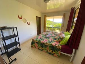 1 dormitorio con cama y ventana en HEIIKIANI Sweet Home, en Nuku Hiva
